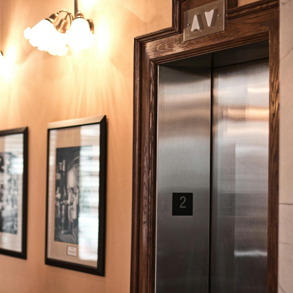 pexels-photo-1281346-1281346 A chic interior featuring an elevator, framed art, and classic wall lighting.