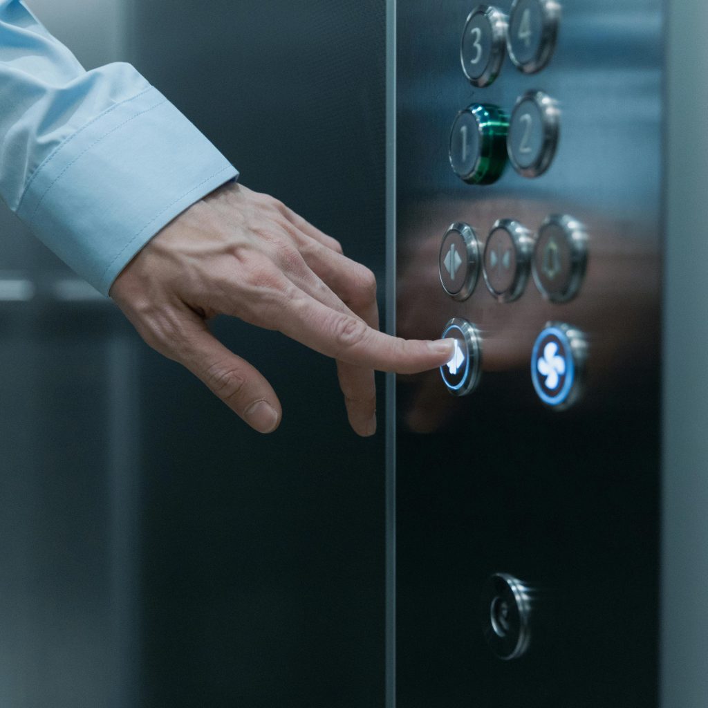 pexels-photo-8453040-8453040-1 A person pressing an elevator button in a modern building, highlighting technology and urban life.