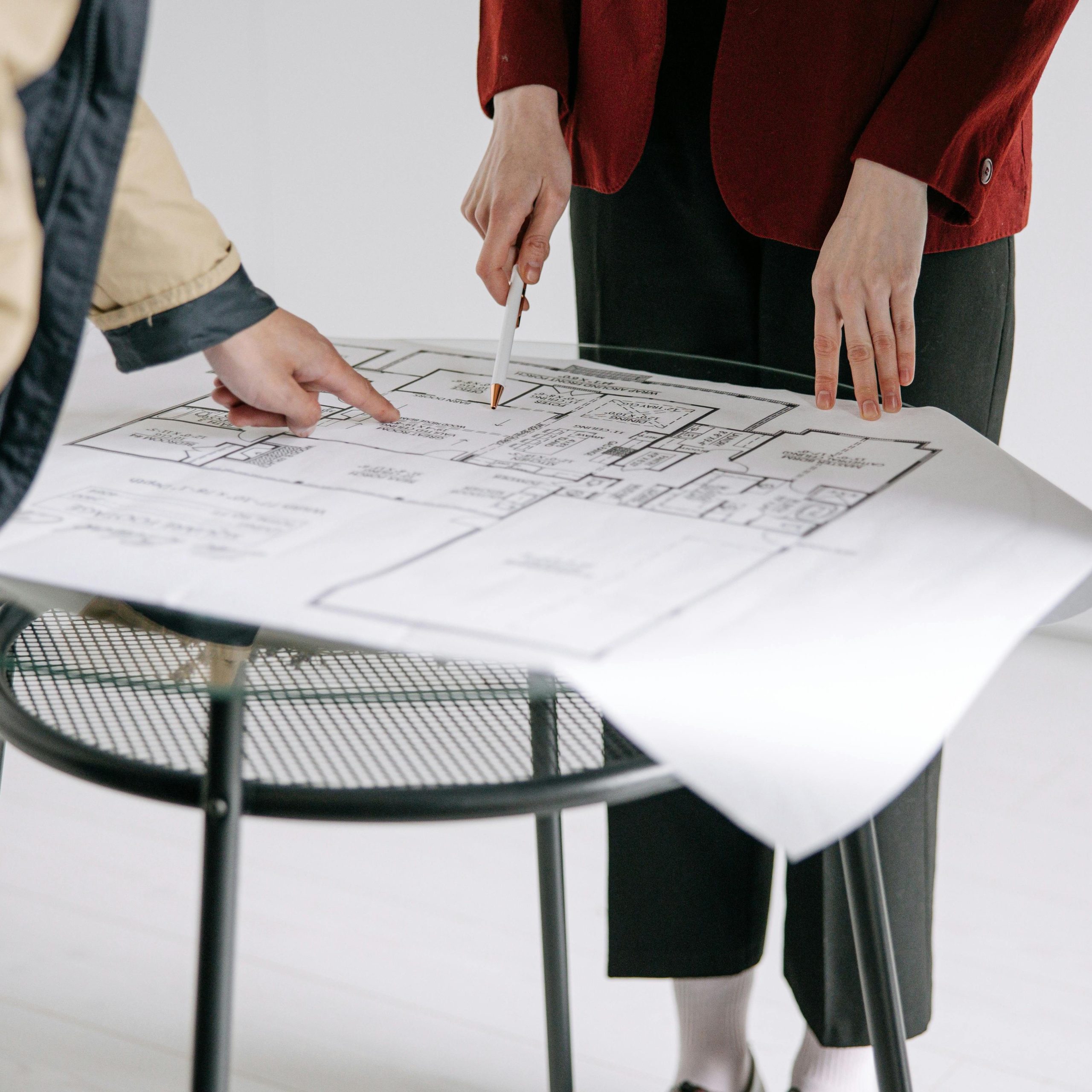 A group of people reviewing architectural blueprints on a table indoors.